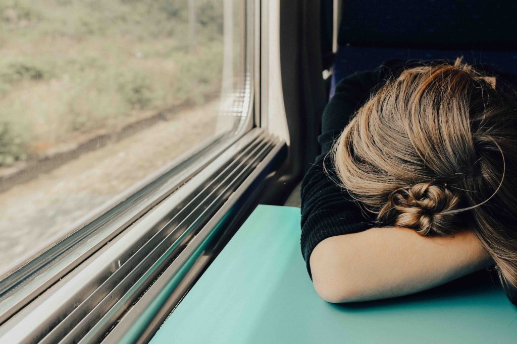 A woman sleeping on a train.